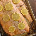 Baked Salmon with Lemon-Dill Sauce on a baking sheet facing left
