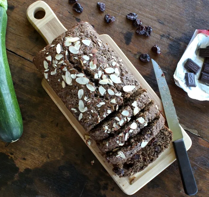 overhead view of a partially cut loaf of Zucchini Bread with Dark Chocolate and Dried Cherries
