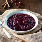 Cranberry Sauce with Red Wine and Ginger in a white bowl sitting on a towel