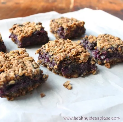 six Blueberry Oat Bars sitting on white paper