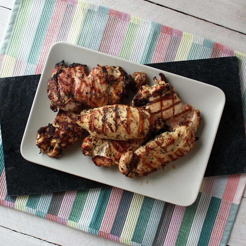 Tray of Lemon and Herb Marinated Chicken on a black cloth