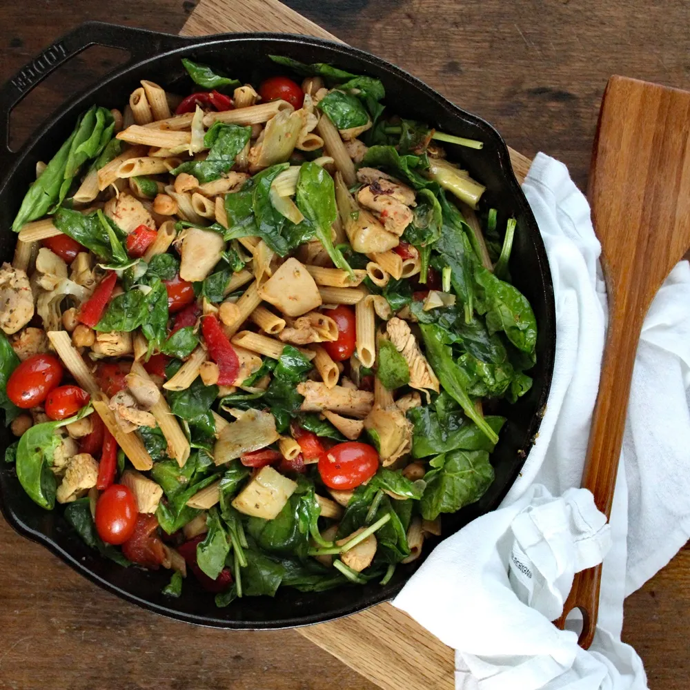 Herbed Chicken and Pasta in a skillet with a wooden spoon