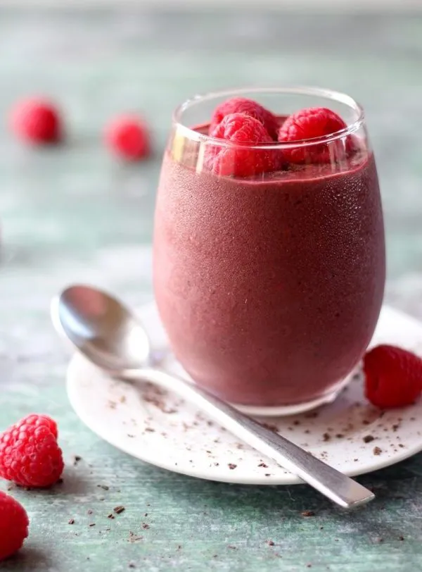 berry smoothie with chocolate on white plate in clear glass