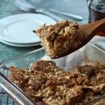 Lifting a piece of breakfast casserole from a pan with a wooden spoon