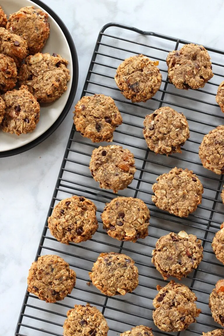 Oatmeal breakfast cookies on cooling rack with plate of cookies nearby