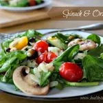 Spinach and Orzo Salad on a white and black plate with a fork