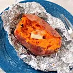 baked sweet potato on foil on blue plate