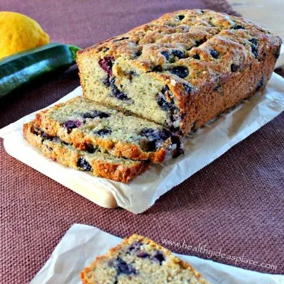 Zucchini Bread with Blueberries and Lemon with a lemon and a zucchini behind