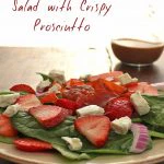 Strawberry and Spinach salad on a plate with the words 