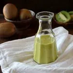 Fresh Kiwi Vinaigrette in a cruet on a white towel