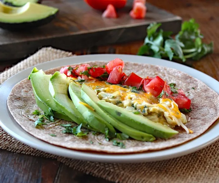 Breakfast Burrito with Eggs, Tomato, and Avocado makes a healthy and satisfying breakfast filled with high quality protein, healthy fats, and tasty veggies.