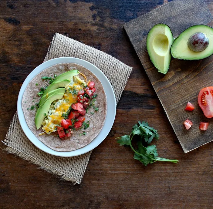 Breakfast Burrito with Eggs, Tomato, and Avocado makes a healthy and satisfying breakfast filled with high quality protein, healthy fats, and tasty veggies.