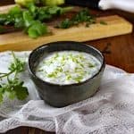 Cilantro Lime Crema in a bowl with ingredients in the background