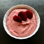 Red lentil roasted beet hummus in a white bowl