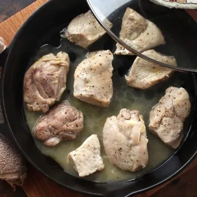 Chicken cooking in a cast iron skillet