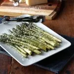 Roasted Asparagus with Parmesan and Garlic on a white serving tray with serving tongs