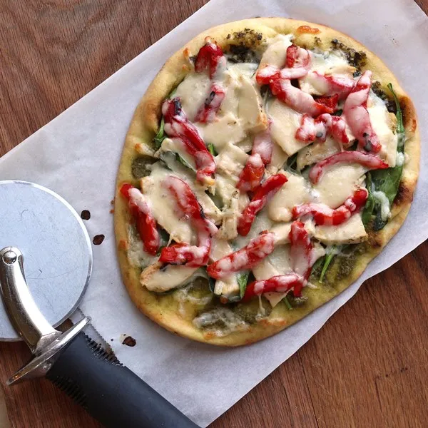 Roasted Red Pepper Chicken and Spinach Naan Pizza on cutting board 