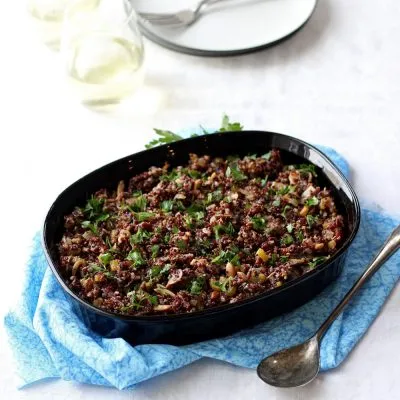 Quinoa Dressing in black dish on blue cloth