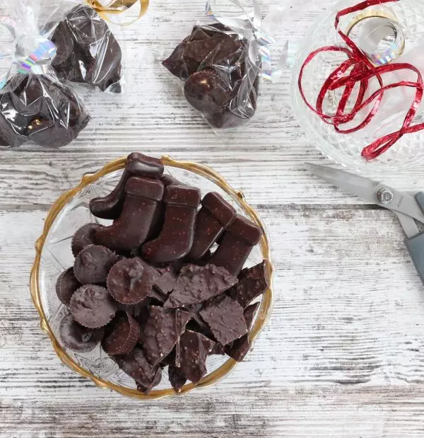 dark chocolate candies in glass bowl against white wood background
