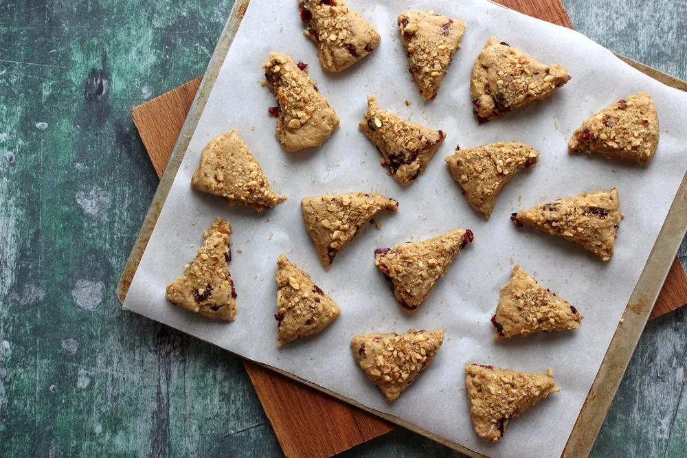 Unbaked scones on a parchment paper lined baking sheet
