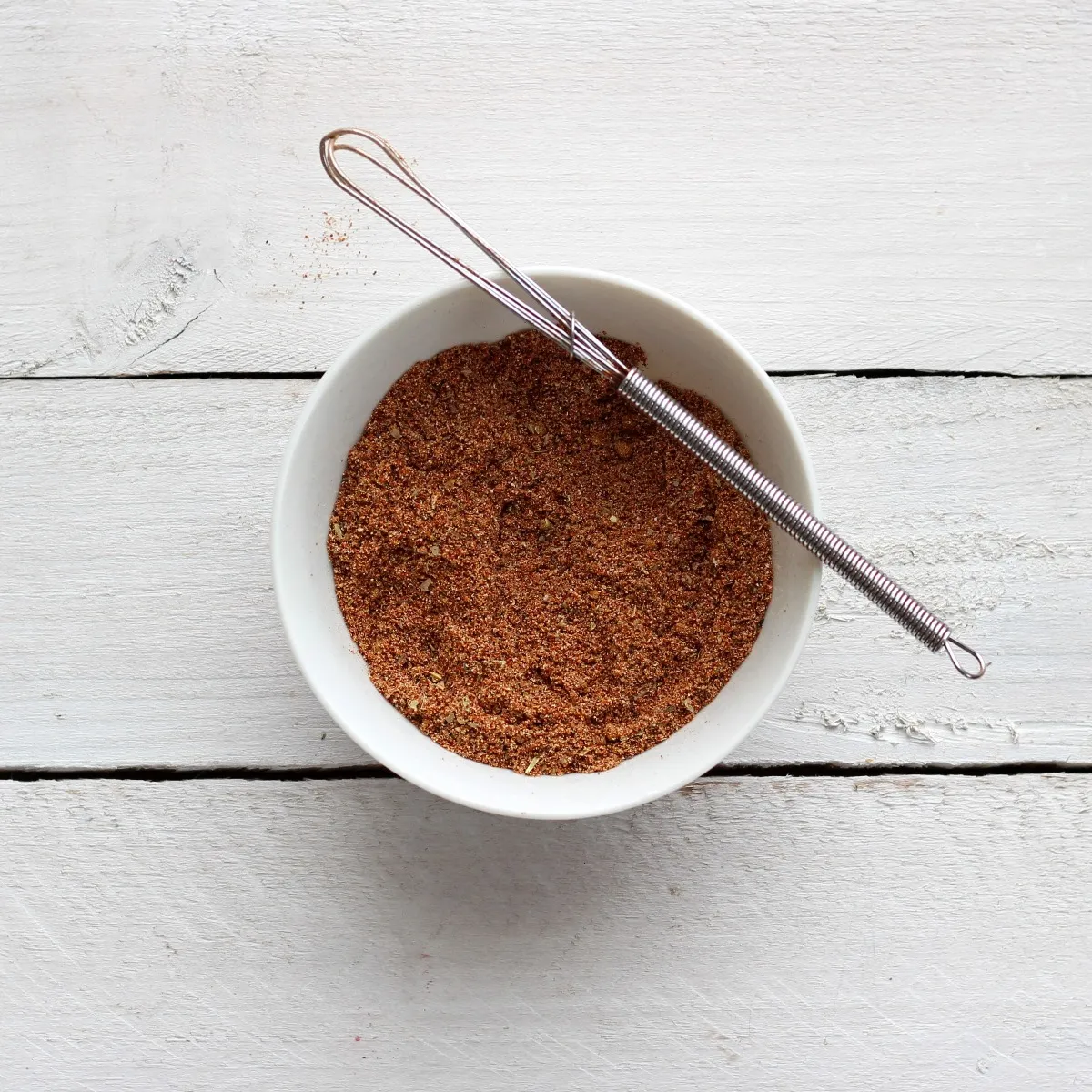 Seasoning mix in white bowl on white backgrond