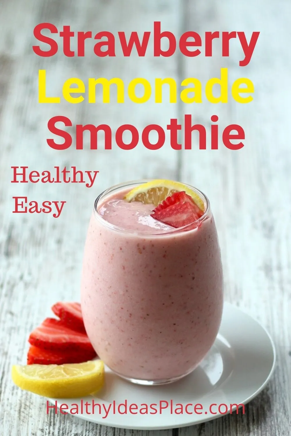 pink smoothie with strawberries and lemon in a clear glass