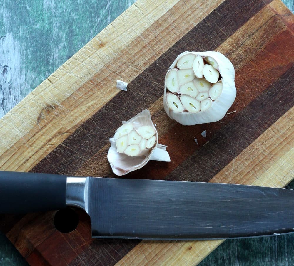 cut garlic on wood cutting board