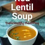 Red Lentil soup in white bowl against green background