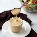 salad dressing in clear jar with salad in background