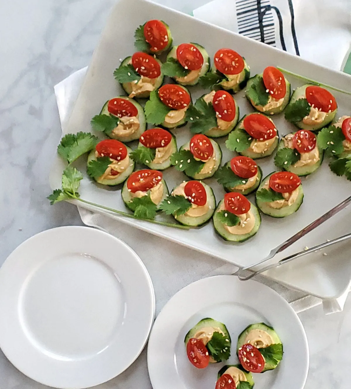 sliced cucumber and hummus appetizer on white plate