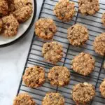 Oatmeal breakfast cookies on cooling rack with plate of cookies nearby