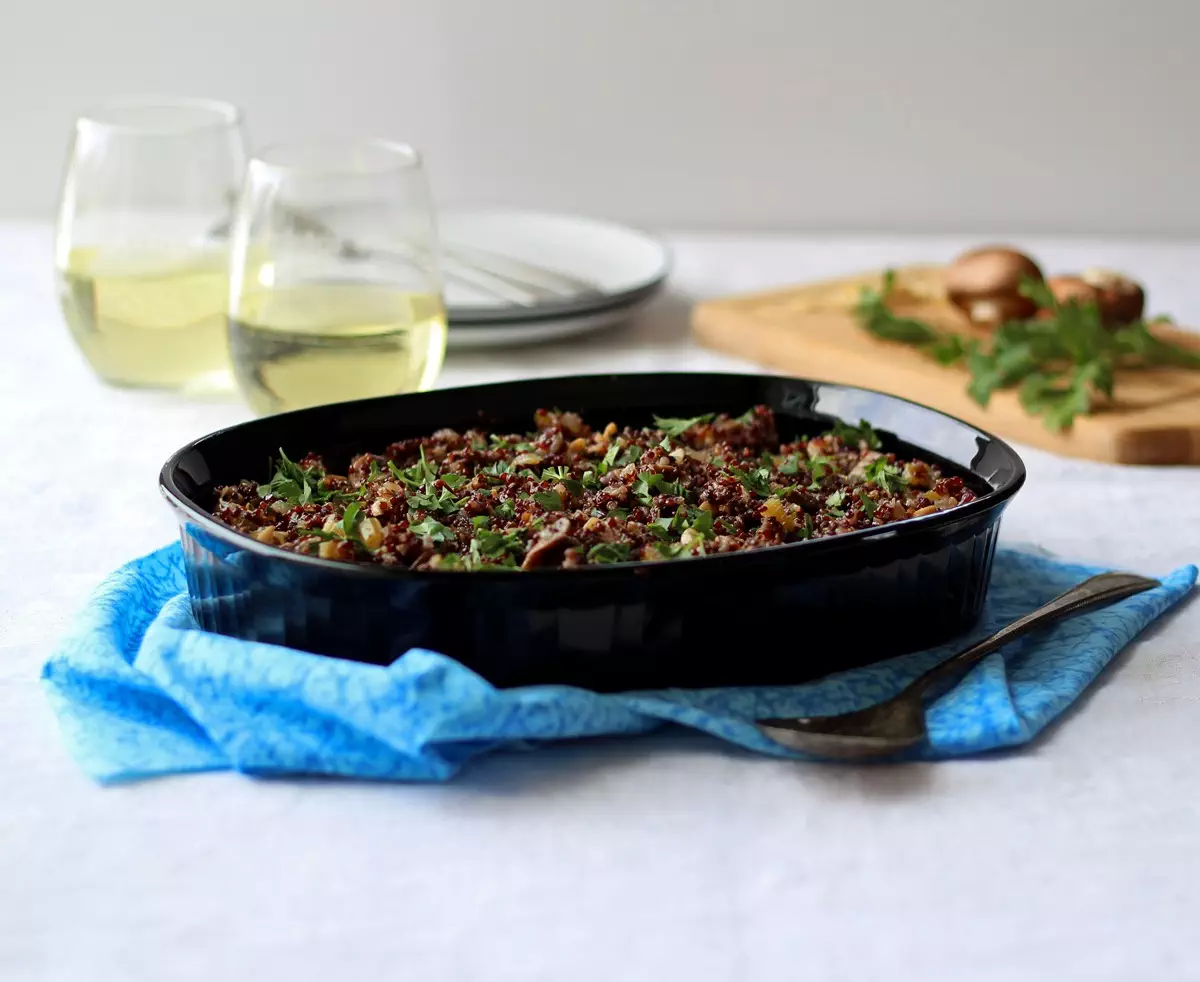 Quinoa stuffing in black dish set on blue fabric
