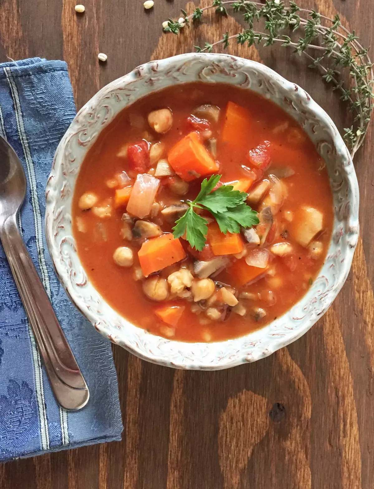 Bean and barley soup in a white bowl against a wood background