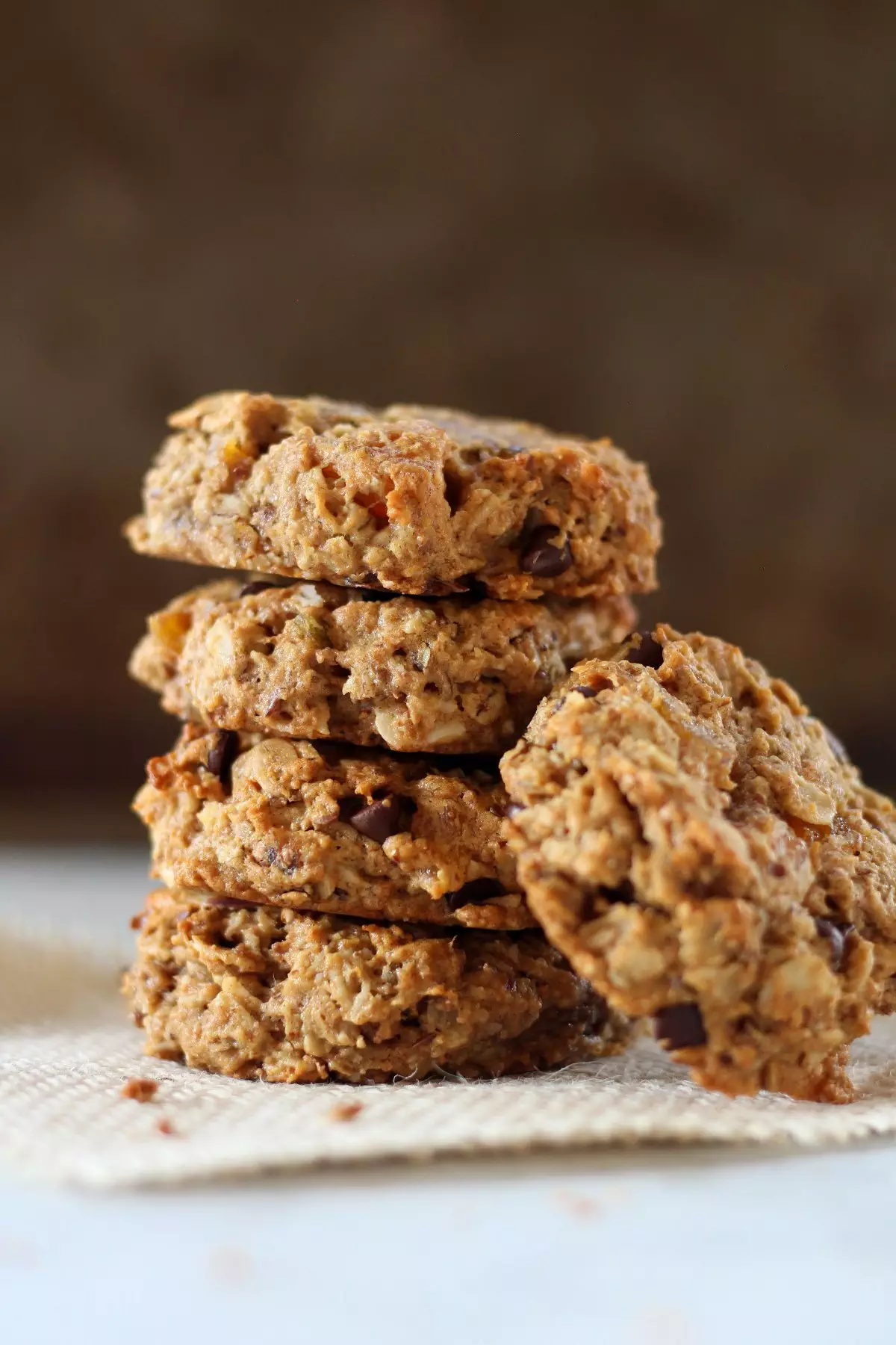 Breakfast cookies stacked on burlap against dark background